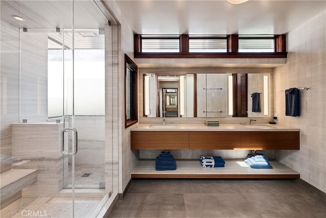 bathroom featuring a stall shower, a sink, and double vanity