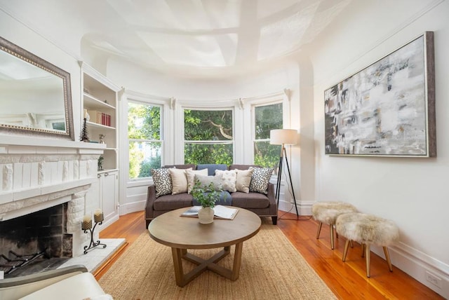 sitting room with built in shelves and light hardwood / wood-style flooring