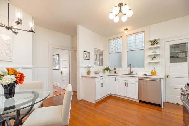 kitchen featuring light hardwood / wood-style floors, stainless steel appliances, a notable chandelier, white cabinets, and sink