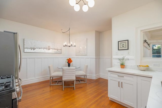 dining space with an inviting chandelier and light hardwood / wood-style flooring