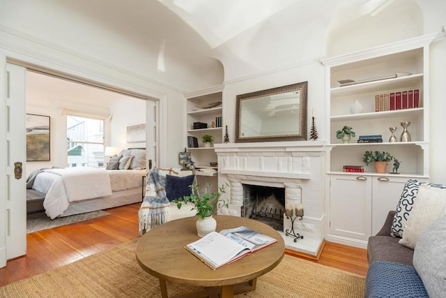 bedroom with a fireplace and light hardwood / wood-style flooring