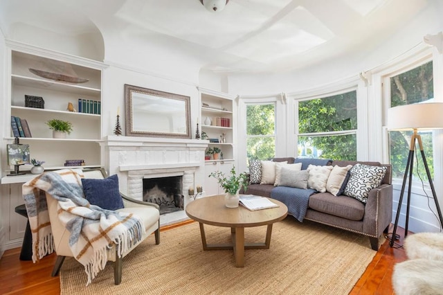 living room with a brick fireplace and light wood-type flooring