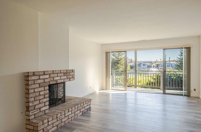 living room featuring a brick fireplace and hardwood / wood-style floors