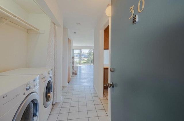 clothes washing area with washer and dryer and light tile patterned floors