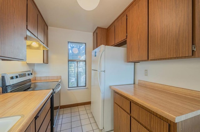 kitchen featuring sink, electric range, white refrigerator, and light tile patterned floors