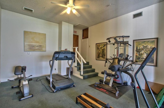 workout area with ceiling fan and a textured ceiling