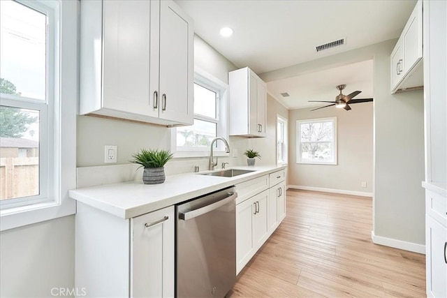 kitchen featuring white cabinetry, dishwasher, sink, and light hardwood / wood-style floors