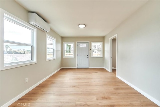 foyer with light wood-type flooring and a wall unit AC