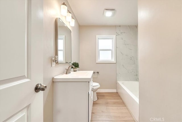 bathroom with hardwood / wood-style flooring, vanity, and toilet