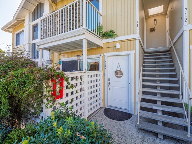 view of exterior entry featuring a balcony