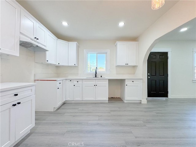 kitchen featuring sink, white cabinets, and light hardwood / wood-style flooring