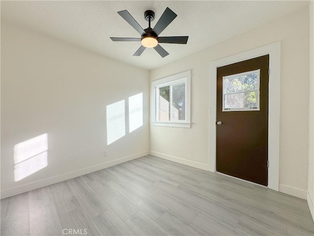 foyer featuring ceiling fan, a wealth of natural light, and light hardwood / wood-style flooring