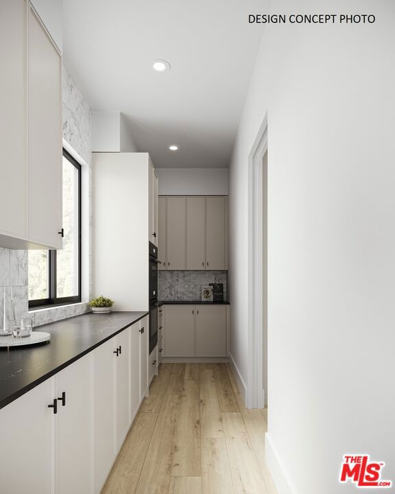 kitchen featuring double oven, white cabinets, light wood-type flooring, and decorative backsplash