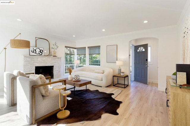 living room with ornamental molding, light hardwood / wood-style flooring, and a fireplace