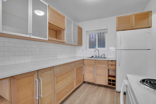 kitchen featuring sink, white refrigerator, decorative backsplash, and light brown cabinetry