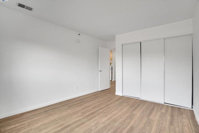 unfurnished bedroom featuring light wood-type flooring and a closet