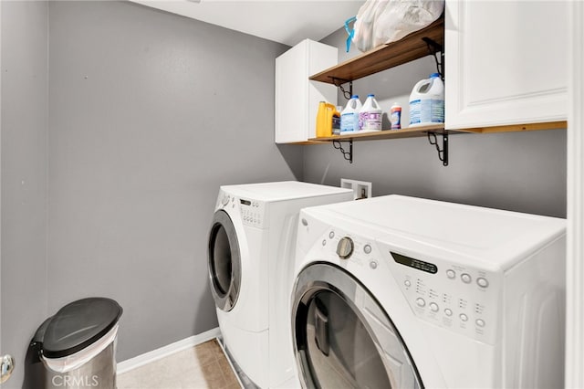 laundry room with washer and dryer, light tile patterned floors, and cabinets