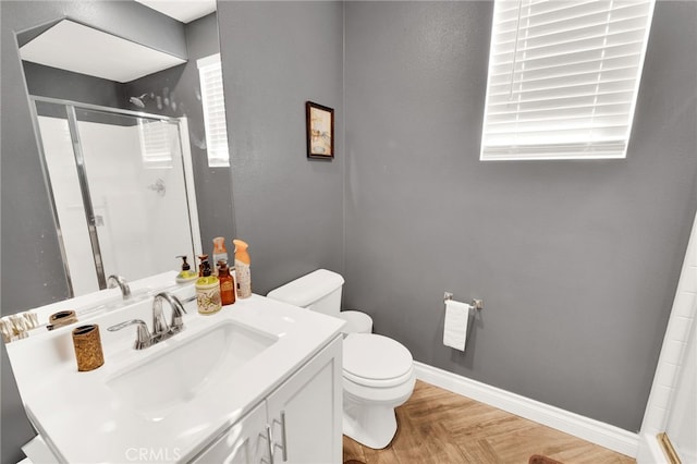 bathroom featuring vanity, parquet floors, a shower with shower door, and toilet