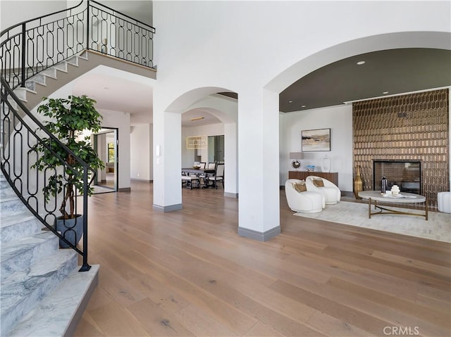 entryway featuring wood-type flooring and a large fireplace