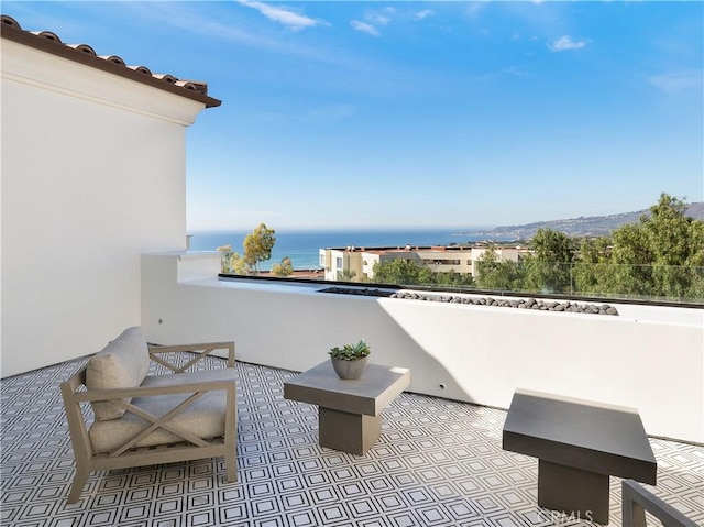 view of patio with a balcony and a water view