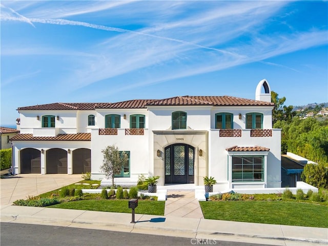 mediterranean / spanish-style house with a balcony, a front lawn, and a garage