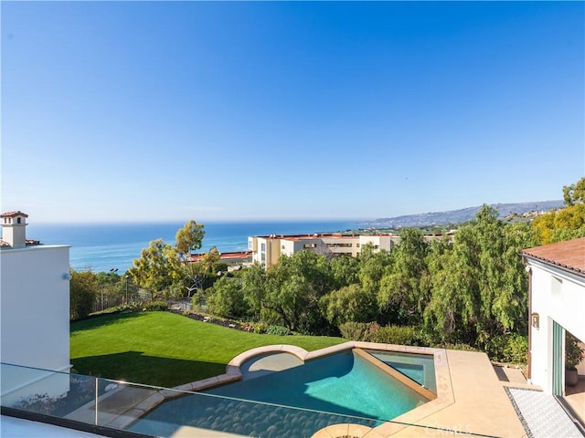 view of swimming pool with a lawn and a water view