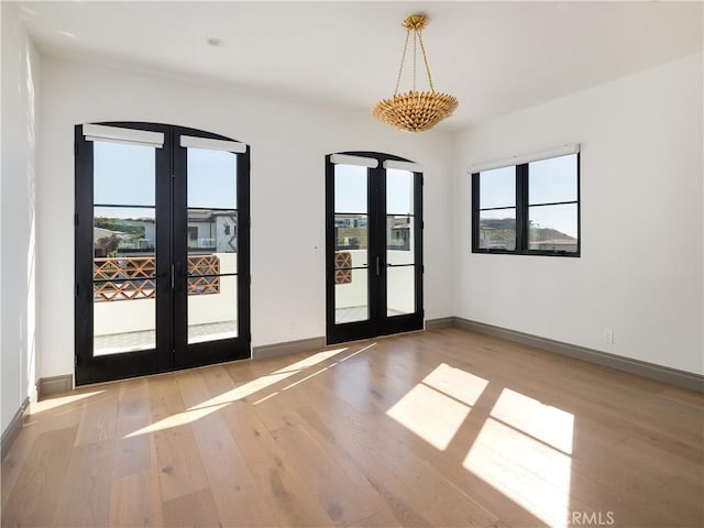 empty room featuring french doors and light wood-type flooring