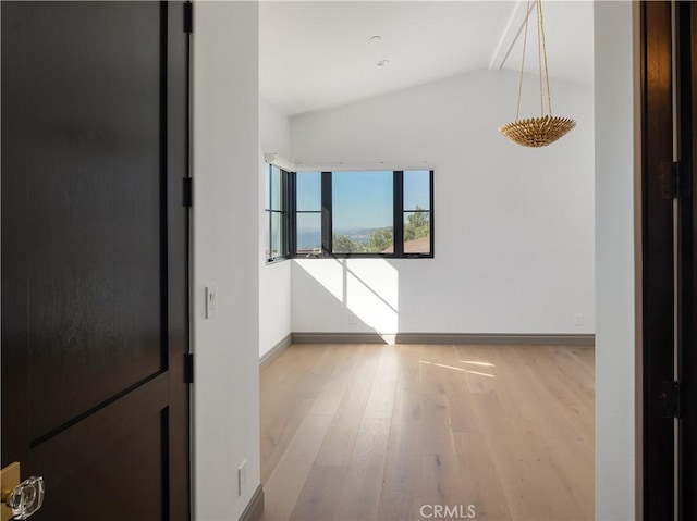 empty room with lofted ceiling and light wood-type flooring