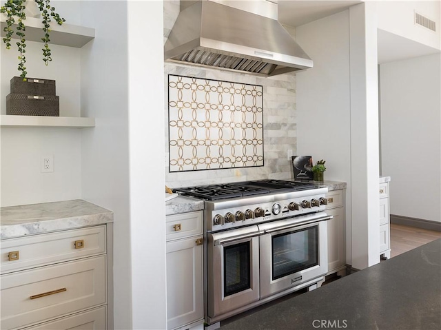 kitchen with range with two ovens, ventilation hood, and decorative backsplash