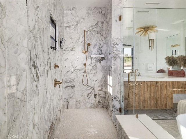 bathroom with tile walls, walk in shower, and vanity