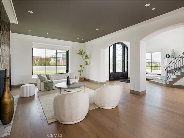 living room with a high end fireplace and light hardwood / wood-style floors