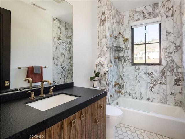 full bathroom featuring toilet, tiled shower / bath combo, and vanity