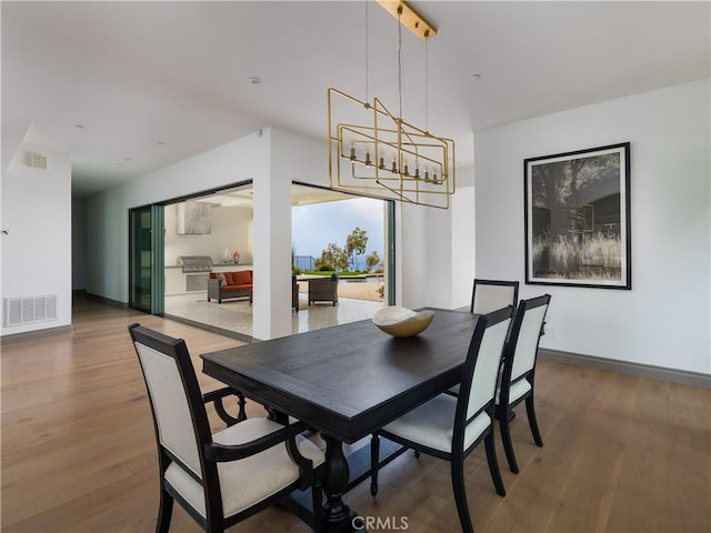 dining space featuring hardwood / wood-style flooring and an inviting chandelier