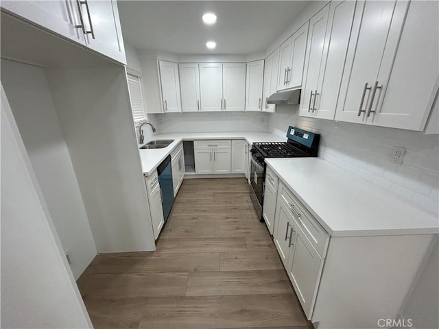 kitchen featuring sink, white cabinetry, stainless steel gas range, light wood-type flooring, and decorative backsplash