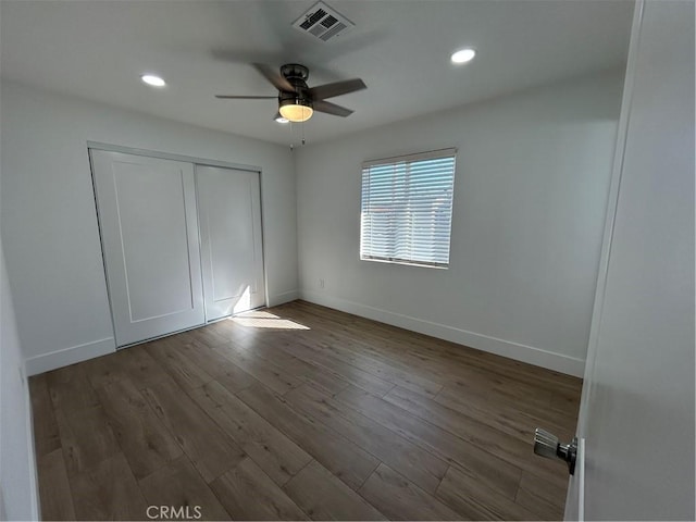 unfurnished bedroom with ceiling fan, hardwood / wood-style floors, and a closet