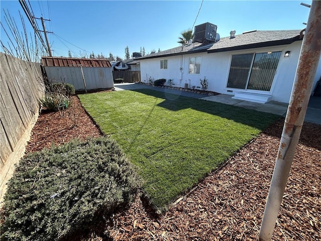 view of yard featuring central AC unit and a storage shed