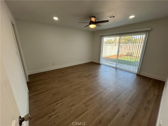 spare room featuring ceiling fan and dark wood-type flooring