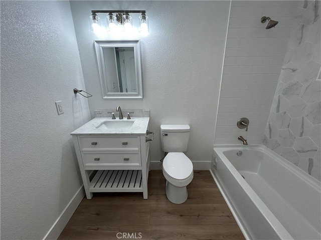 full bathroom featuring toilet, vanity, hardwood / wood-style flooring, and tiled shower / bath