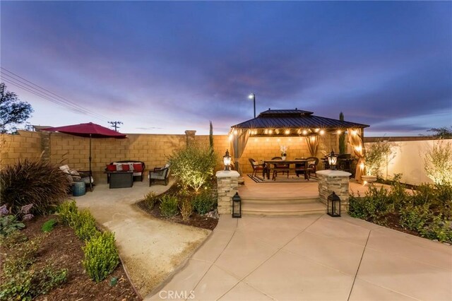 patio terrace at dusk featuring a gazebo