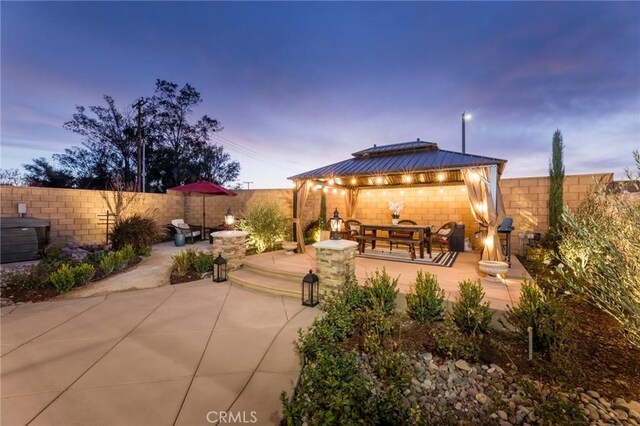 patio terrace at dusk with a gazebo and an outdoor fire pit