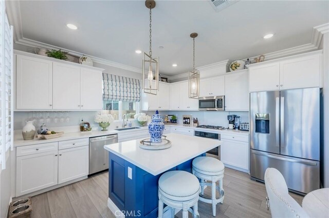 kitchen featuring white cabinets, sink, stainless steel appliances, and a center island