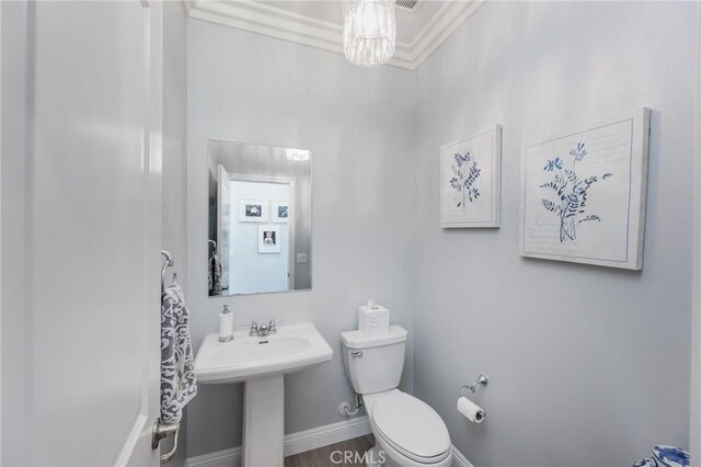 bathroom with sink, wood-type flooring, toilet, and crown molding