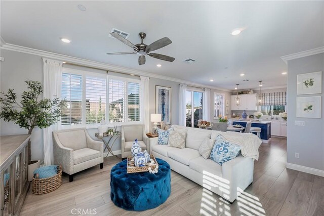 living room featuring light wood-type flooring, ceiling fan, and crown molding