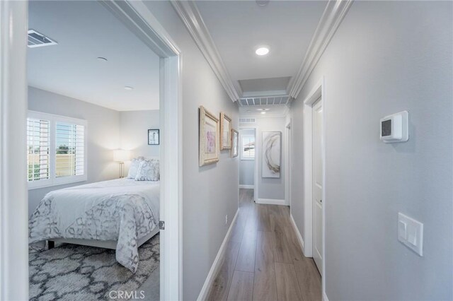 corridor featuring light hardwood / wood-style flooring and crown molding