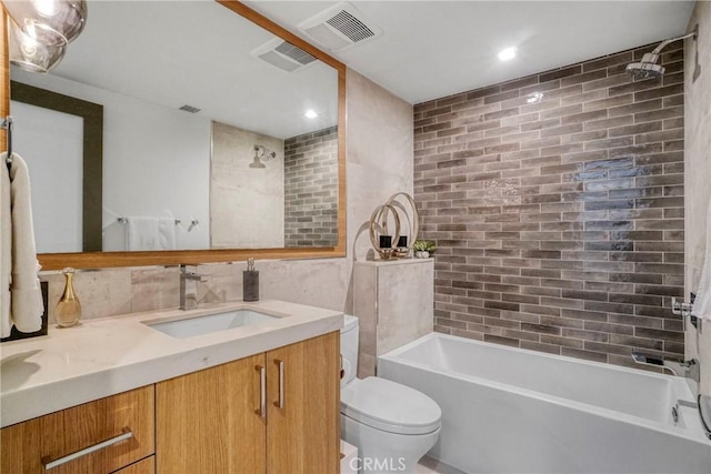 full bathroom with toilet, vanity, and tiled shower / bath