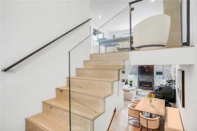 stairway featuring tile patterned floors and a fireplace