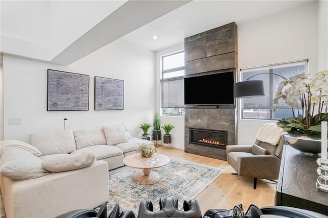 living room featuring wood-type flooring and a tile fireplace