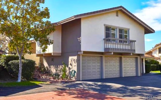 view of front property featuring a garage and a balcony