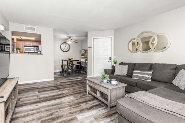 living room with wood-type flooring and ceiling fan