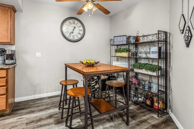 dining area with ceiling fan and dark hardwood / wood-style flooring